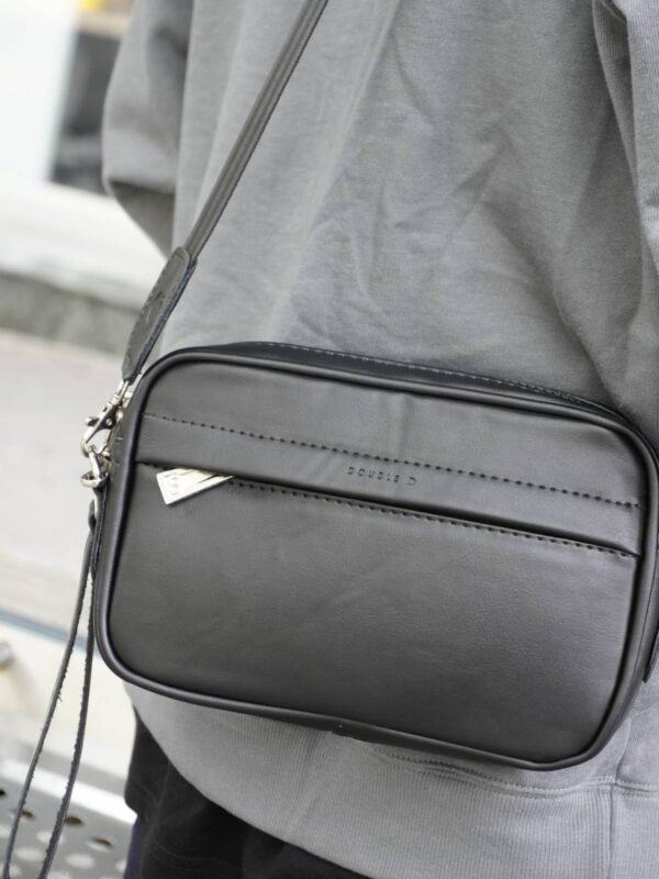 Manos libre liso de color negro unisex, accesorio versátil colombiano. Bolsos y accesorios en Colombia con diseño moderno y funcional.